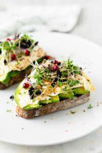 Delicious and nutritious avocado toast topped with sprouts and seeds, perfect for a healthy breakfast.